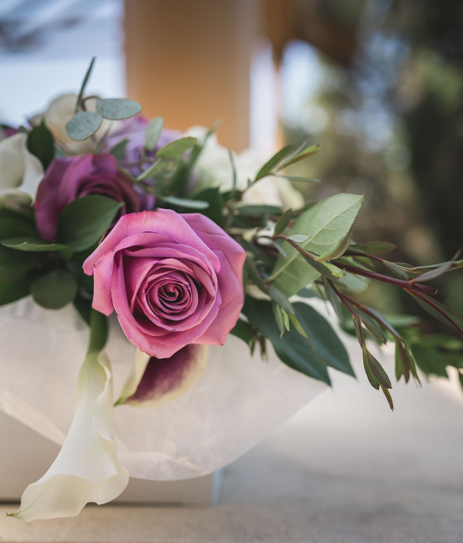 Pink roses with green foliage arranged in a decorative display on a light surface.