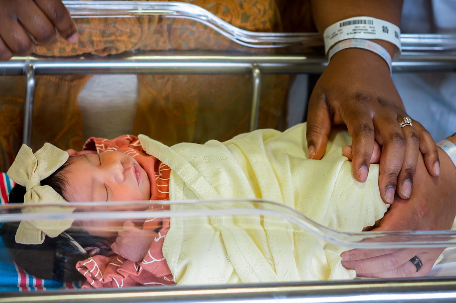 A series of medical professionals examining newborn babies in yellow hospital blankets.