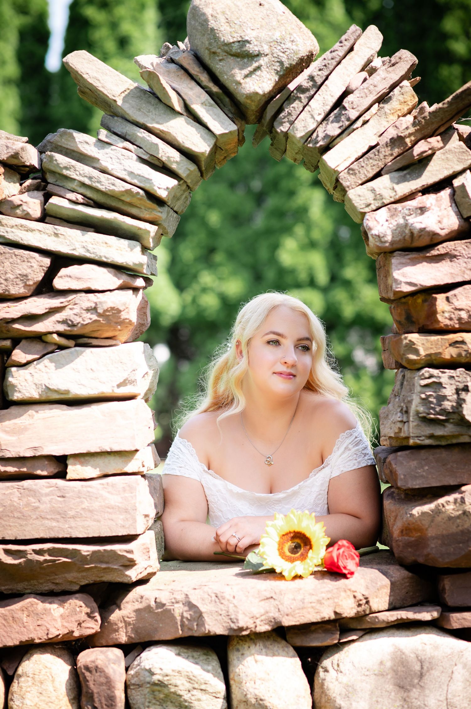 Rustic stone archway frames a serene garden moment with a bright sunflower.