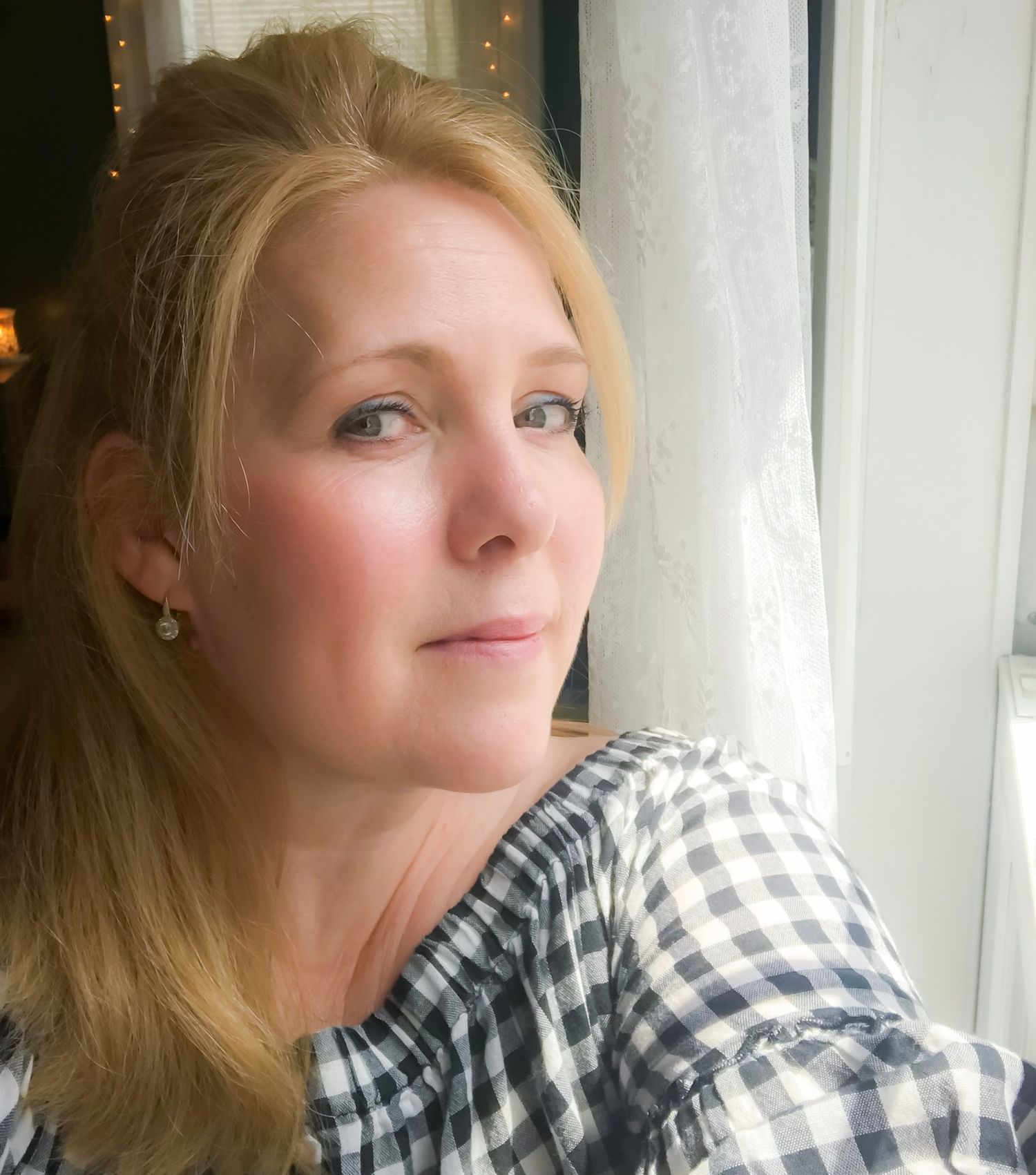 A series of five self-portrait photos showing a person in a black and white checkered shirt looking thoughtfully by a window.