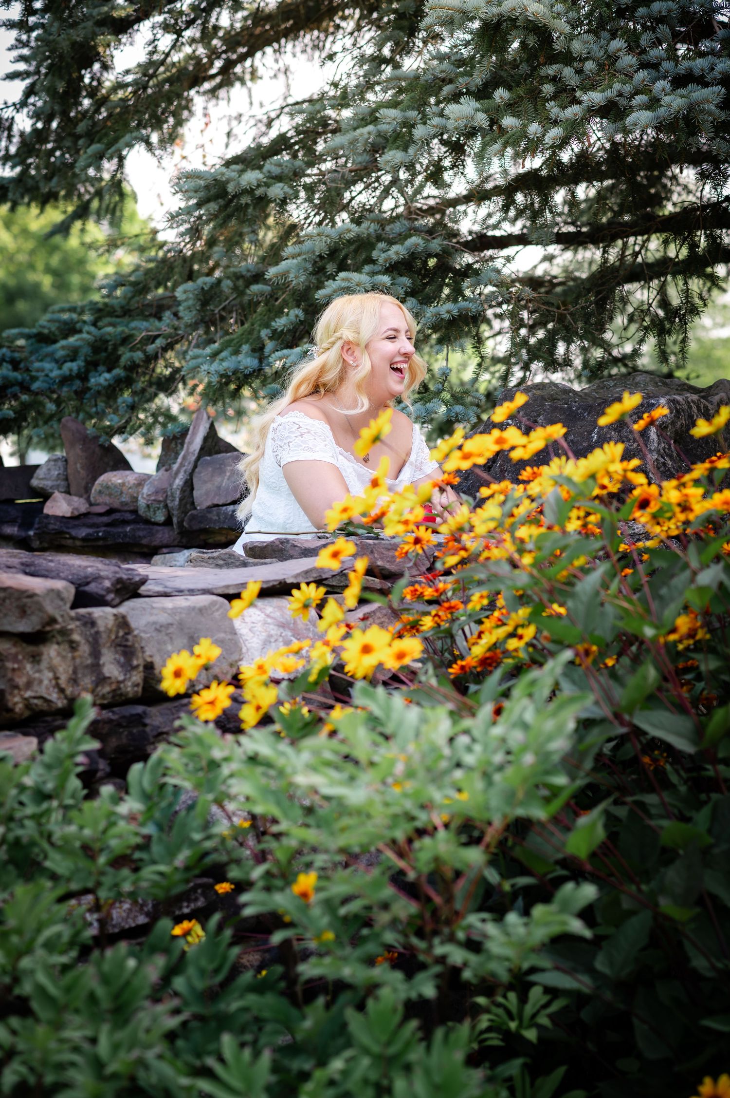 A joyful moment captured among yellow flowers and stone landscaping in a garden.