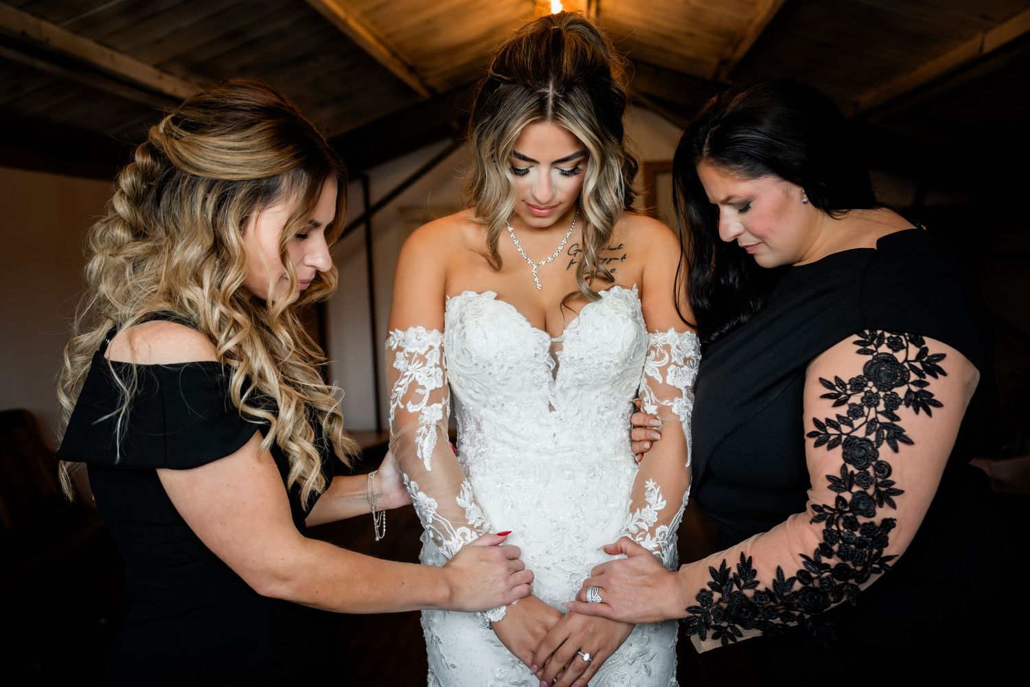A group helps adjust a white wedding dress in a series of black and dark-toned preparation photos.