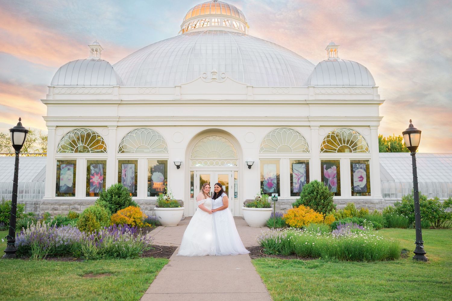White domed wedding venue with colorful garden flowers at sunset.