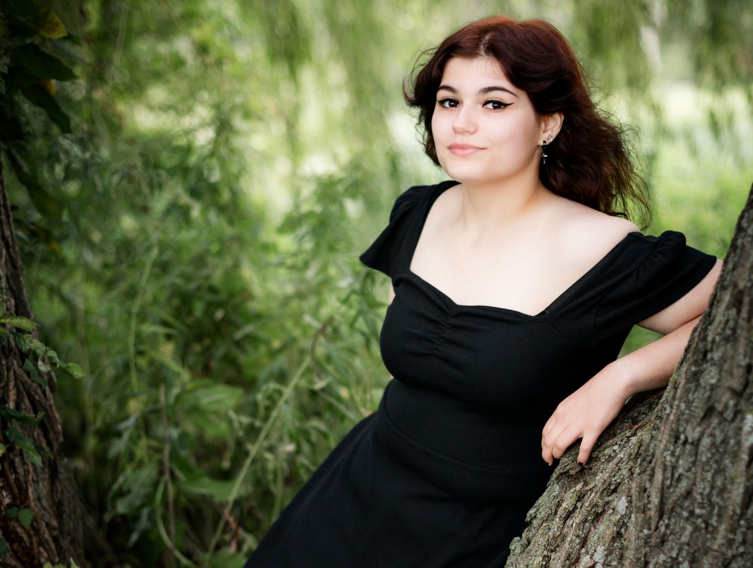 Artistic black and white style portrait captured against a textured tree trunk backdrop.