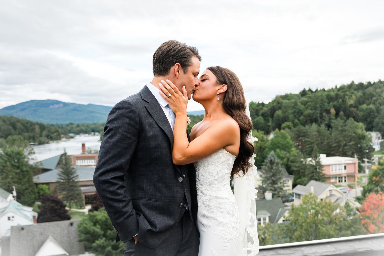 A scenic mountain backdrop frames a romantic rooftop wedding moment.