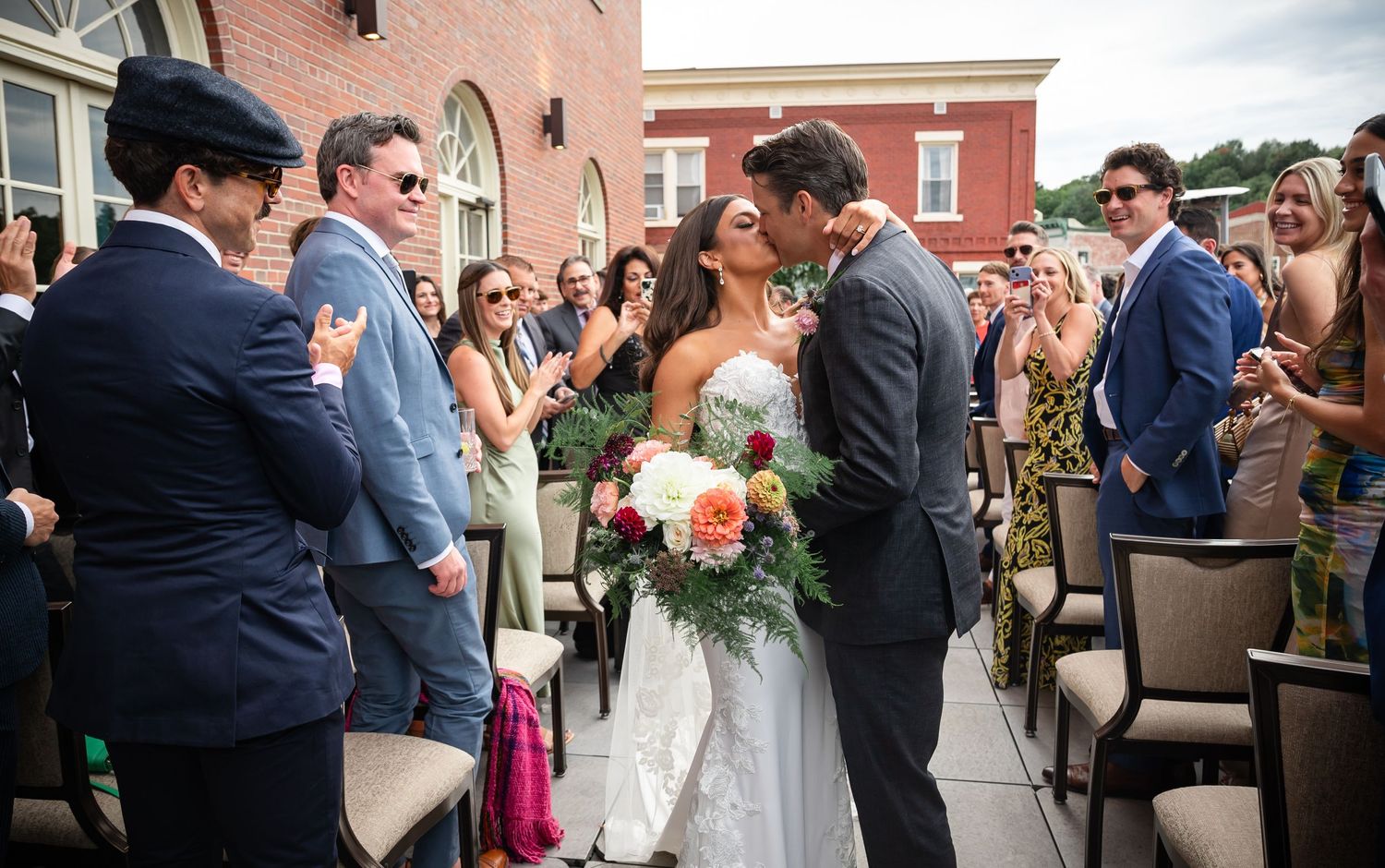 Wedding ceremony moment on rooftop venue with brick building background.
