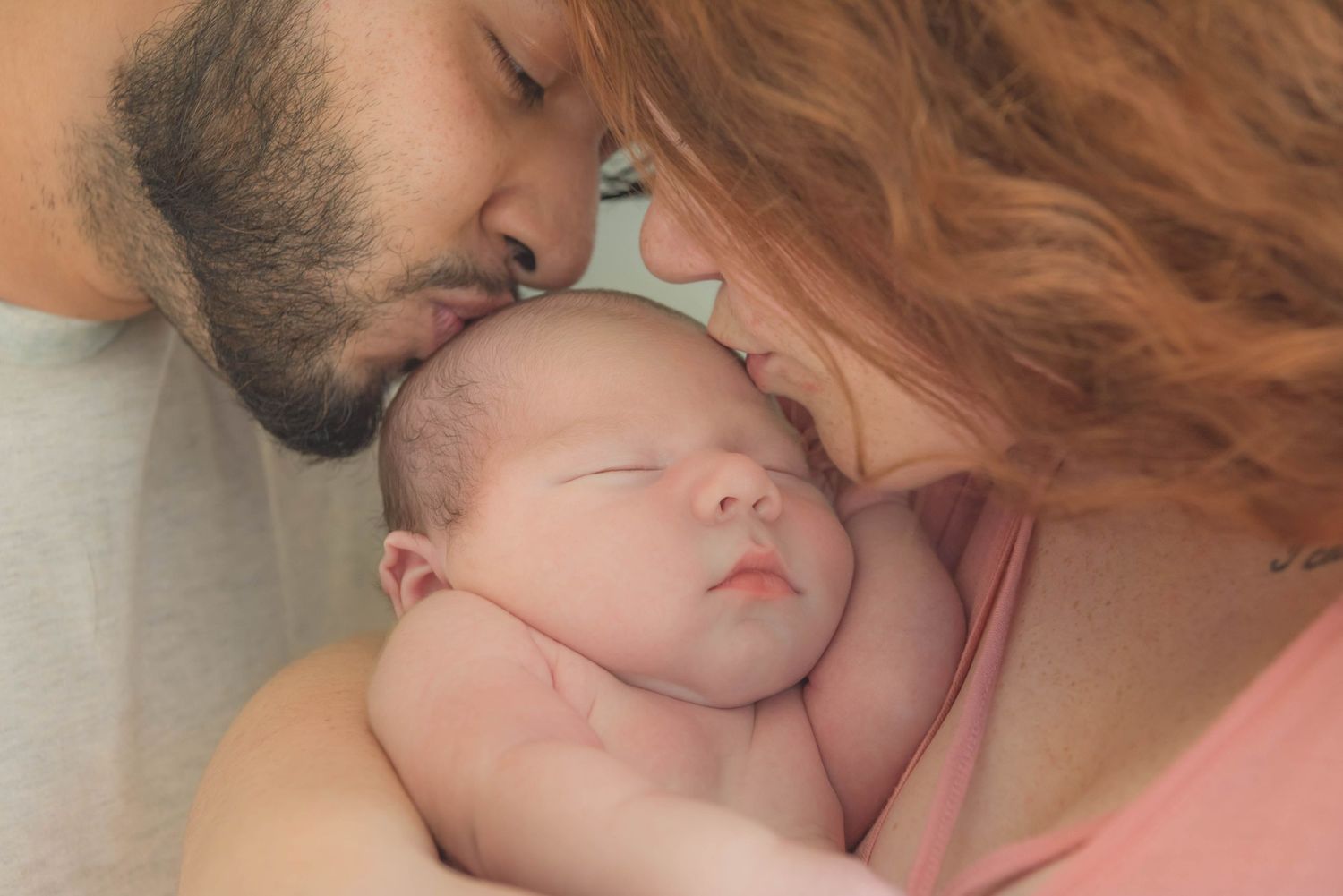 A tender moment captured between a parent and sleeping baby in a series of close-up photographs.