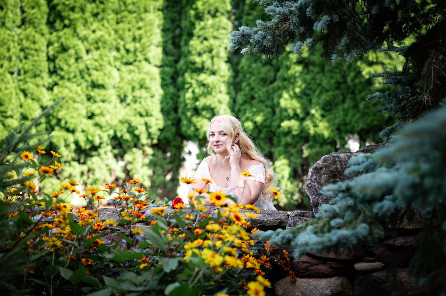 A lush garden blooms with bright orange and yellow flowers against verdant greenery.