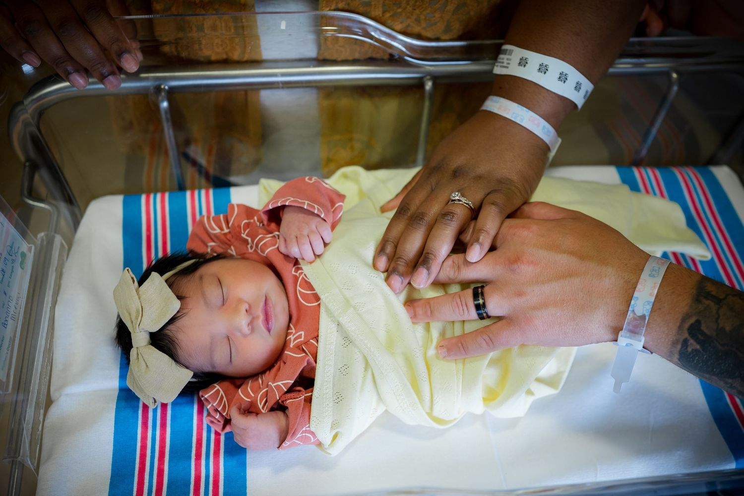 Medical staff examining and measuring newborn baby on hospital table.