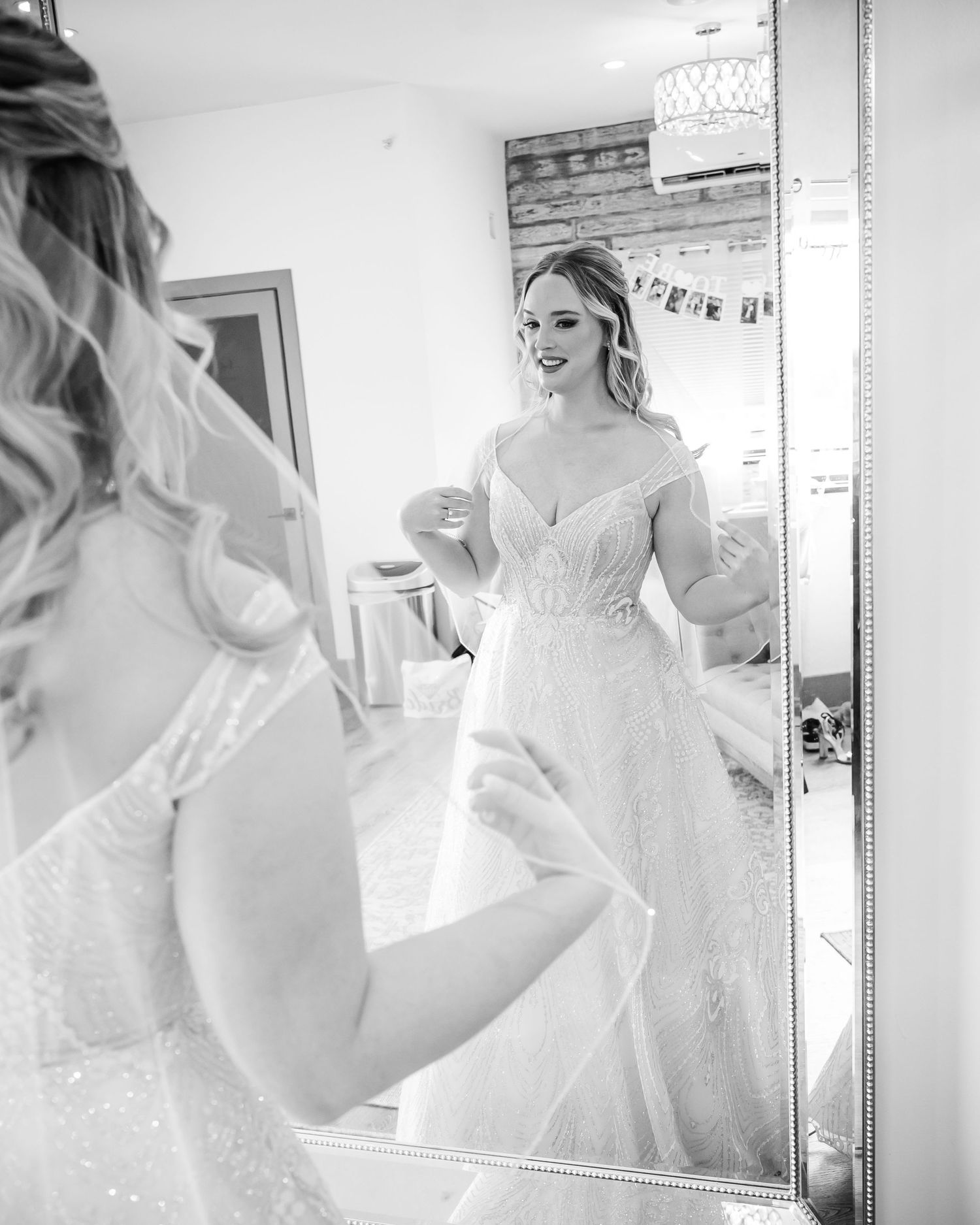 Black and white portrait of wedding dress reflection in elegant mirror.