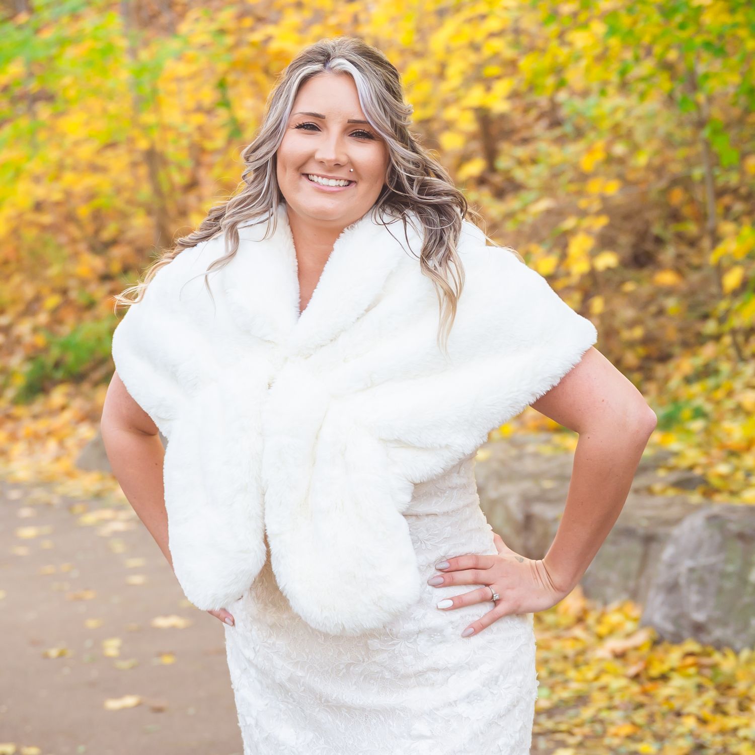 Portrait in white dress against vibrant yellow fall foliage background.