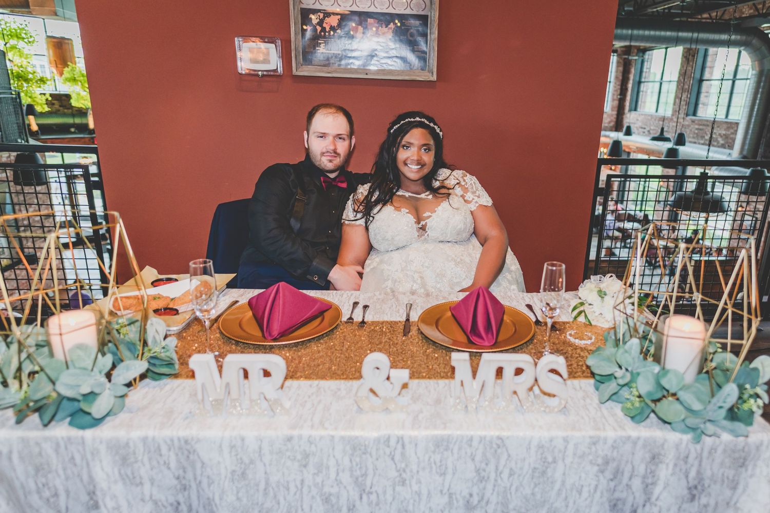 A wedding reception head table decorated with turquoise accents and elegant place settings.