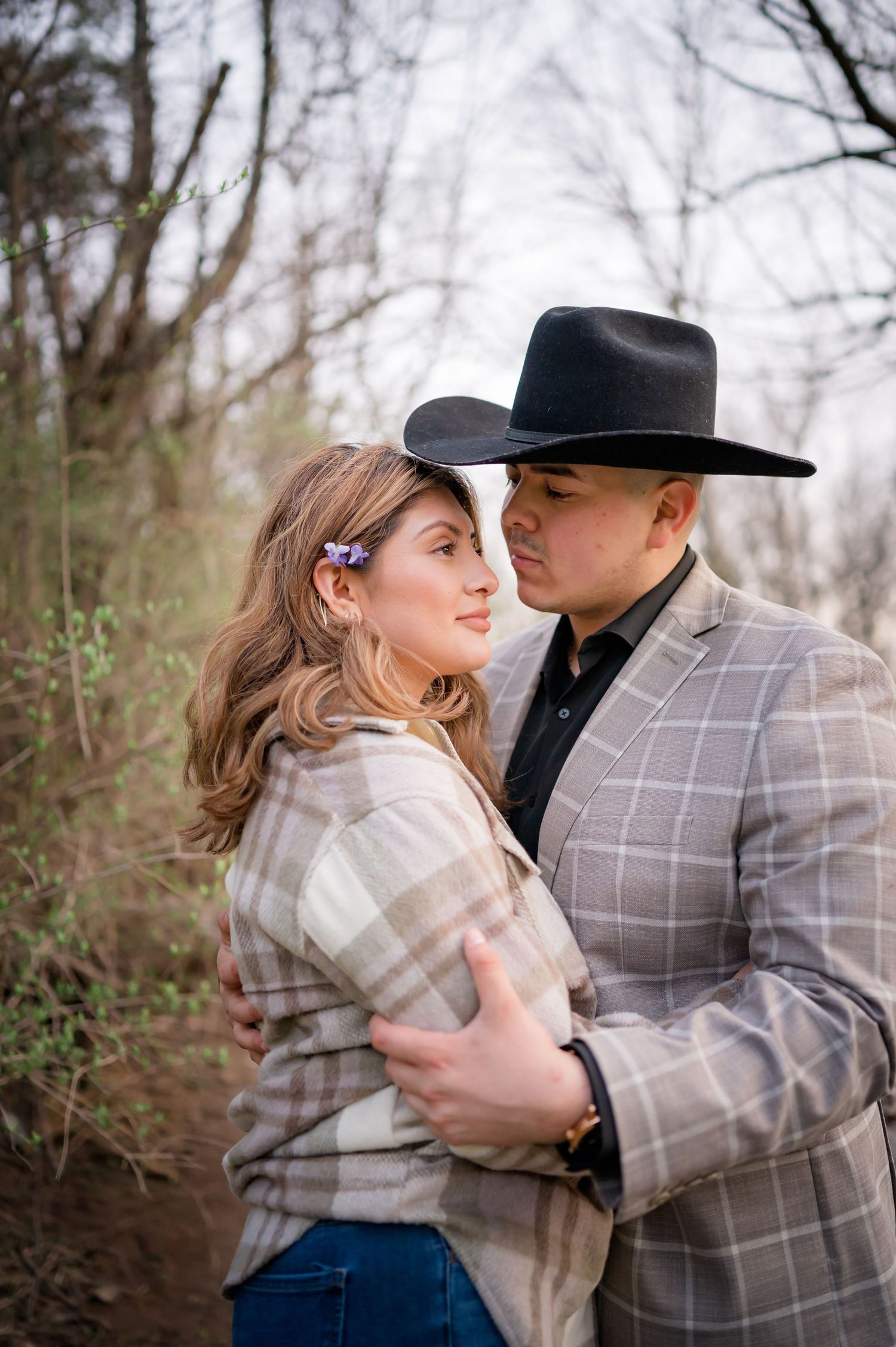A romantic embrace captured in nature with soft lighting and rustic styling.
