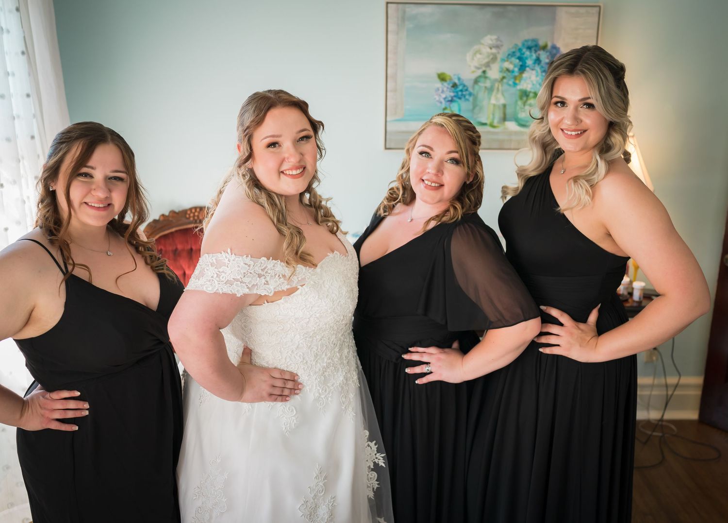 A bridal group shares a joyful moment while posing in formal attire.