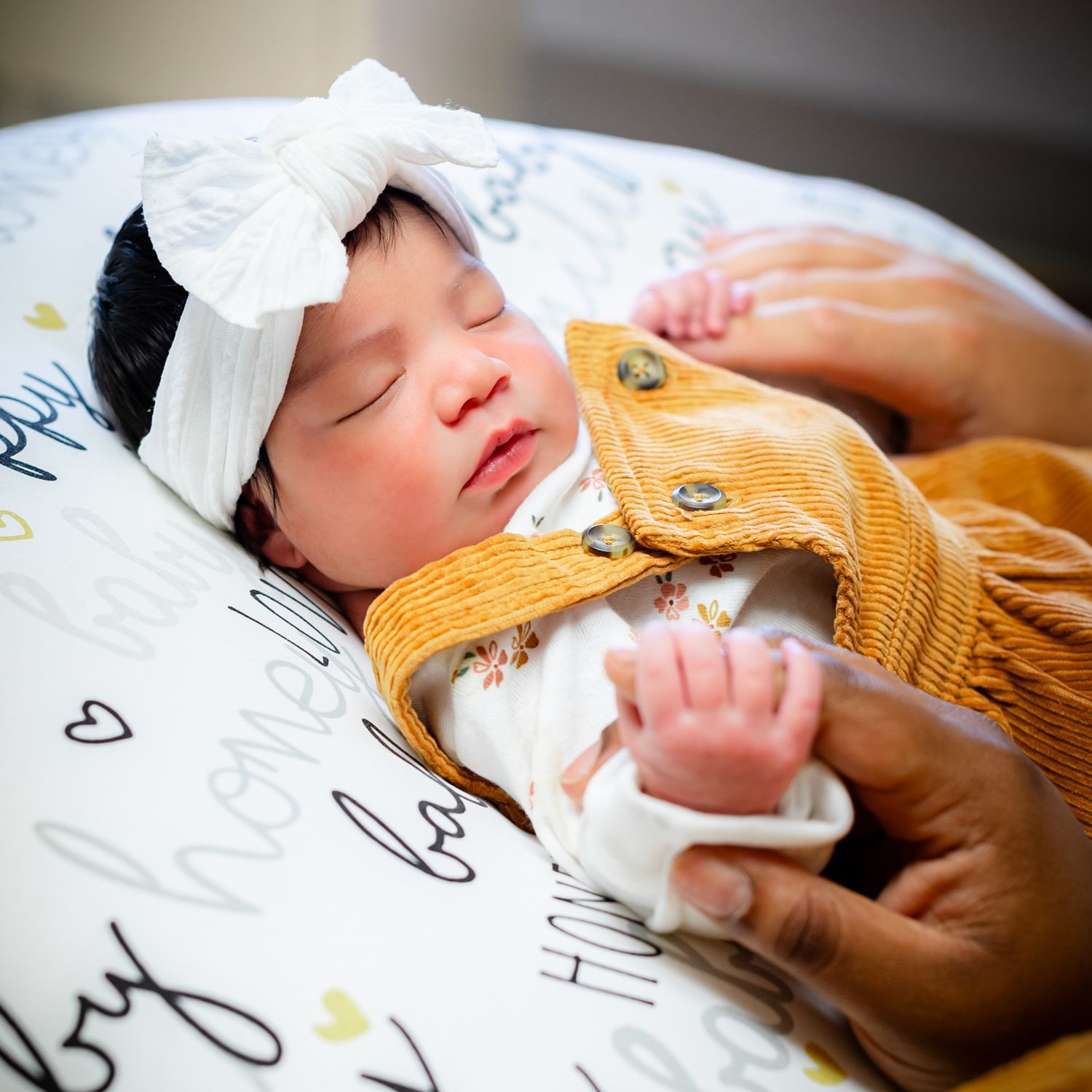 Close-up view of a sleeping infant swaddled in yellow with white bedding.