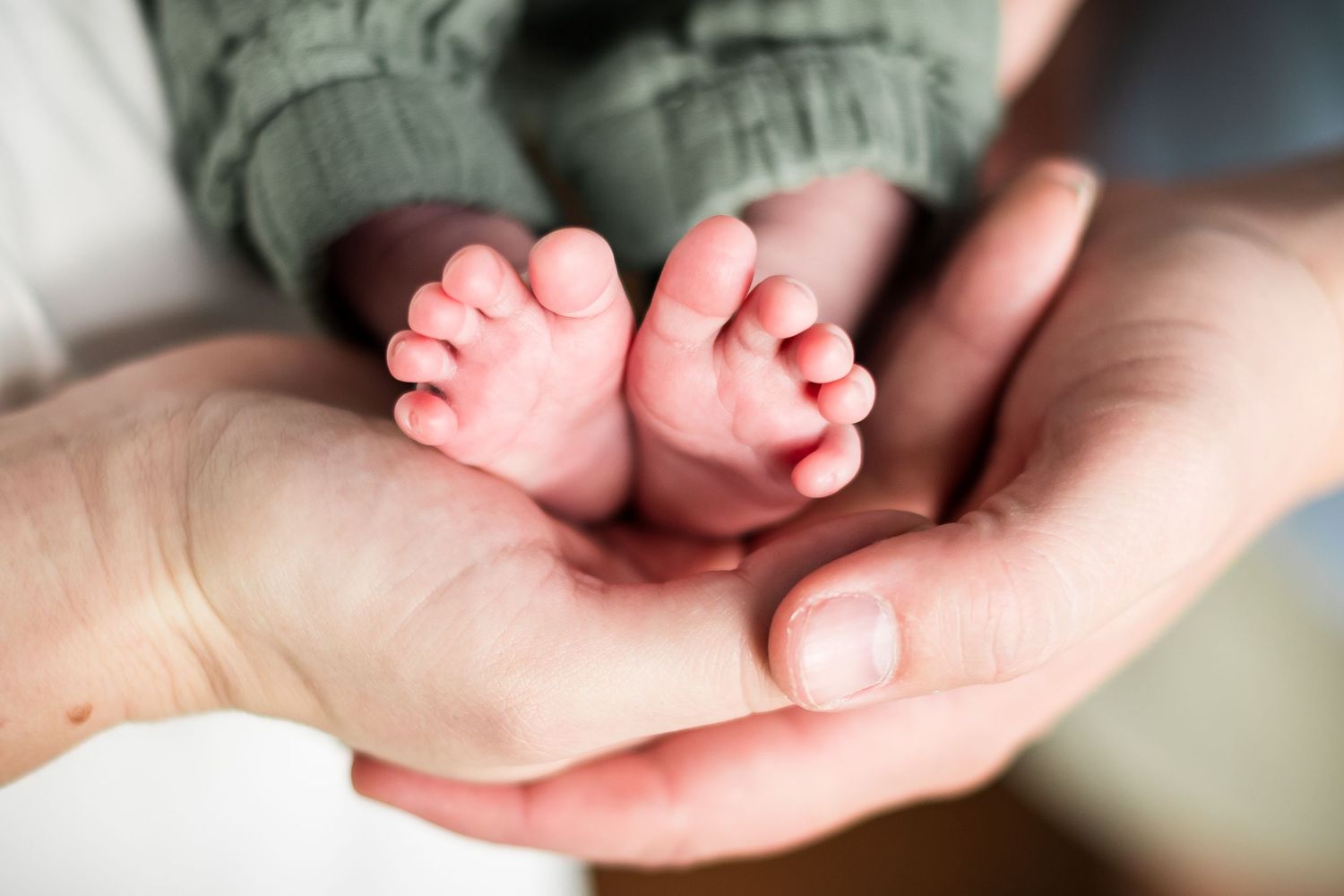 A series of images showing tiny baby feet being gently held in adult hands.