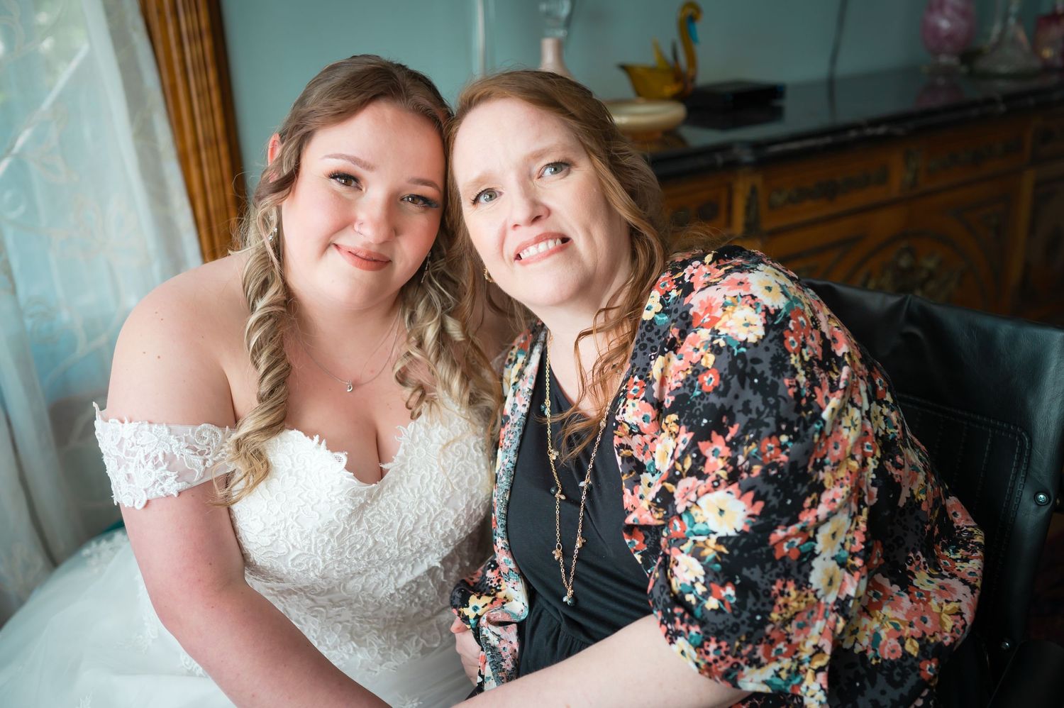 Two people share intimate moment during wedding preparations in vintage-style room.