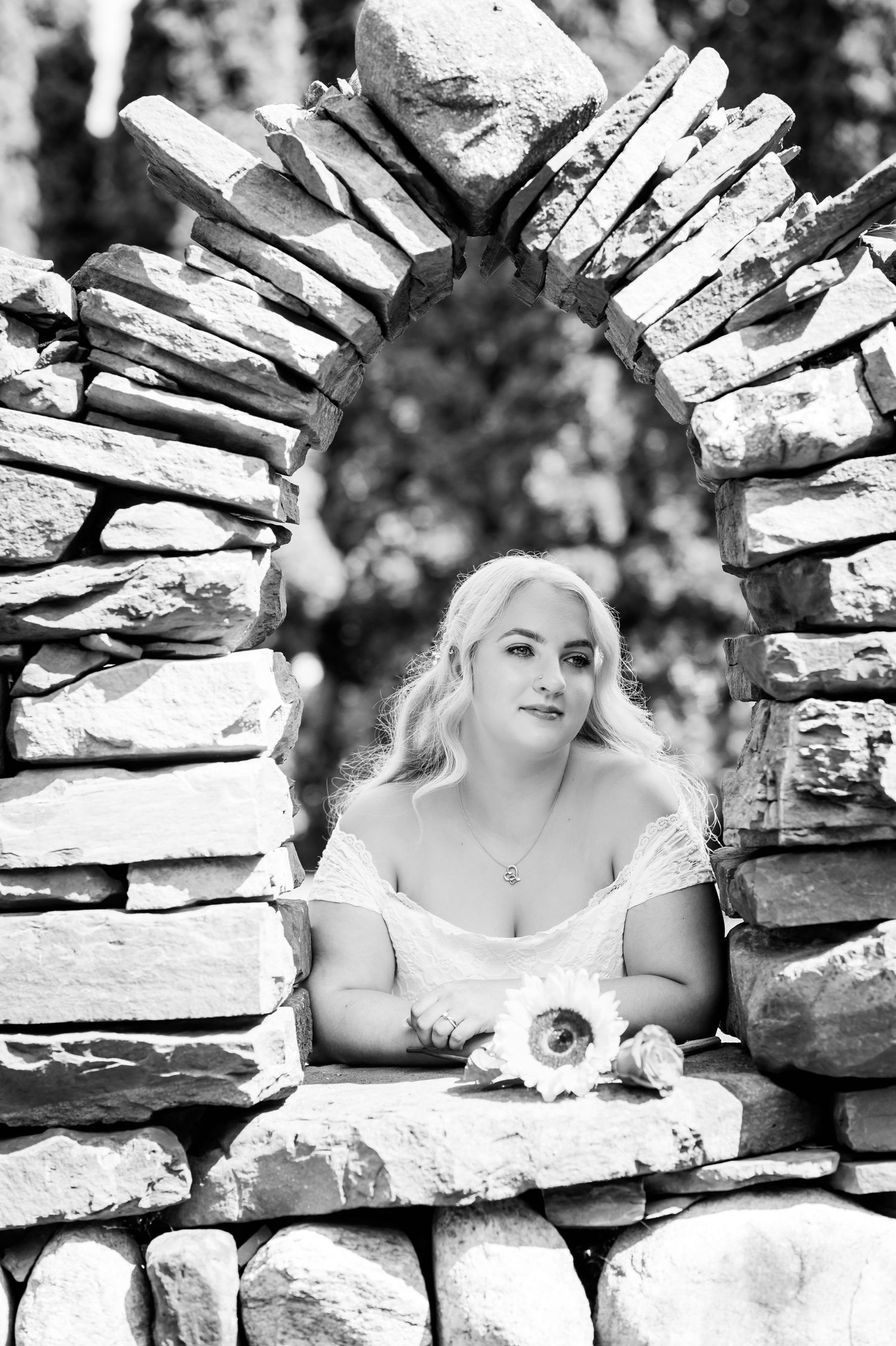 Black and white photo showcases intricate stonework of a garden arch.