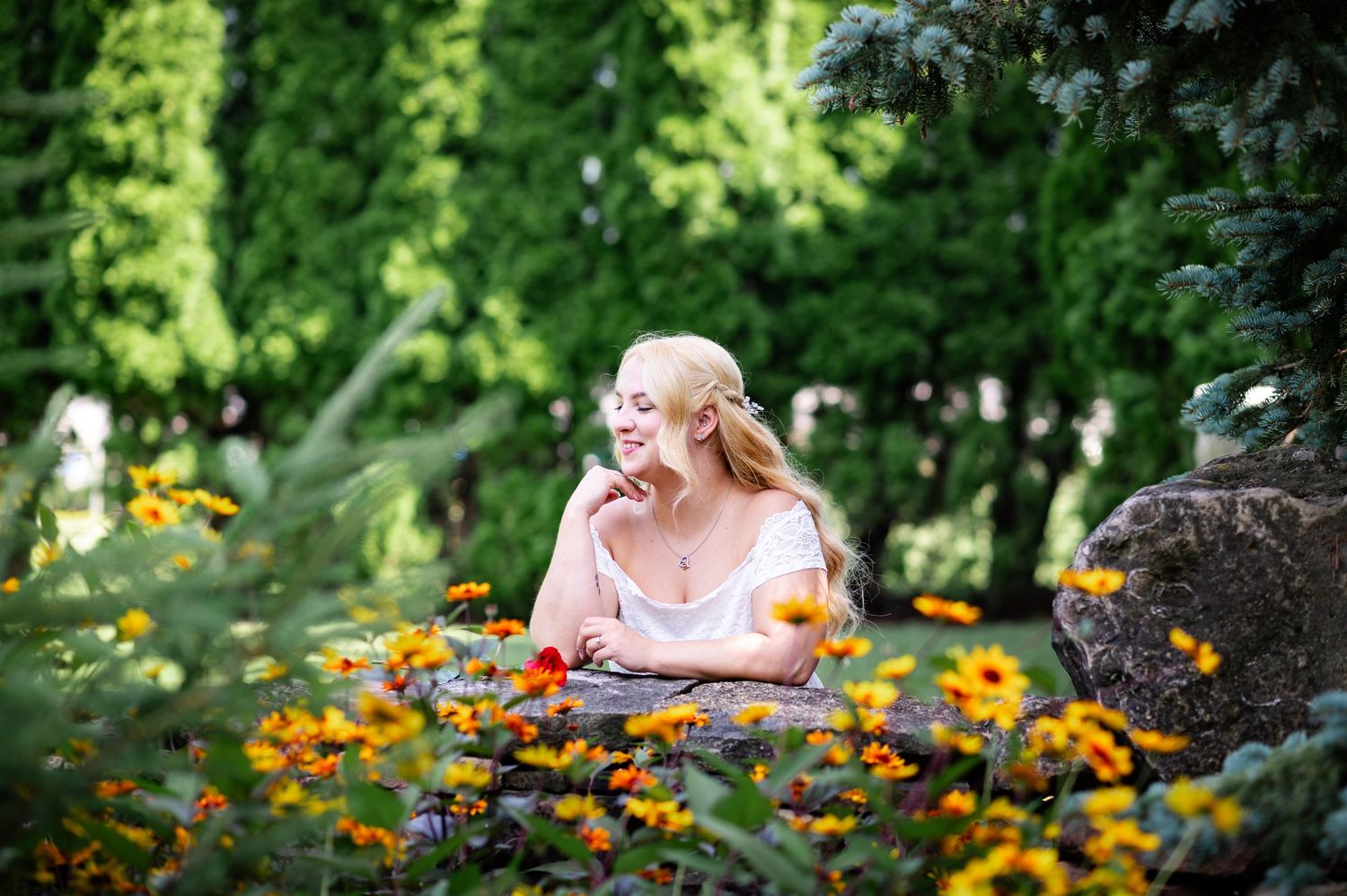 A dreamy garden portrait with orange flowers in the foreground and soft natural lighting.