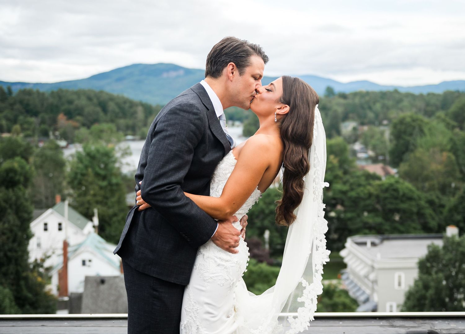 Romantic wedding portrait with mountain village backdrop.