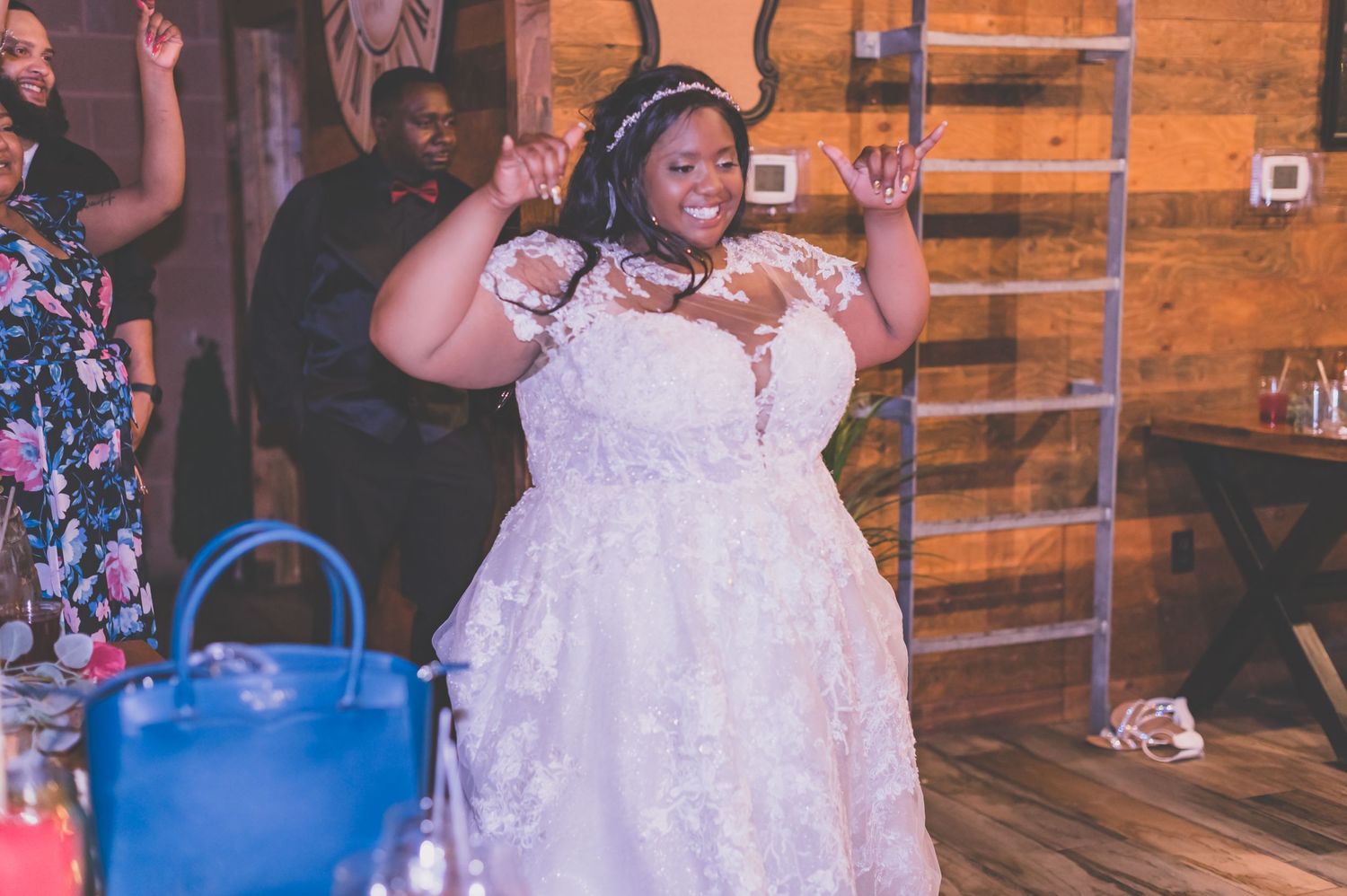 A joyful celebration with a bride in a beautiful lace dress dancing at the reception.