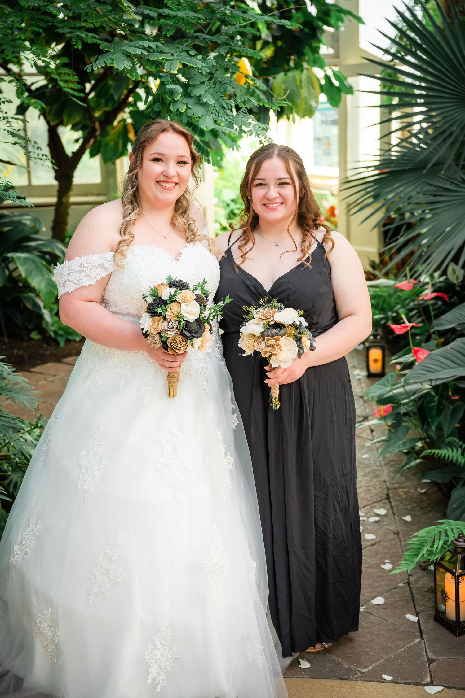 Wedding couple in white dress and black formal wear pose together in a garden setting.
