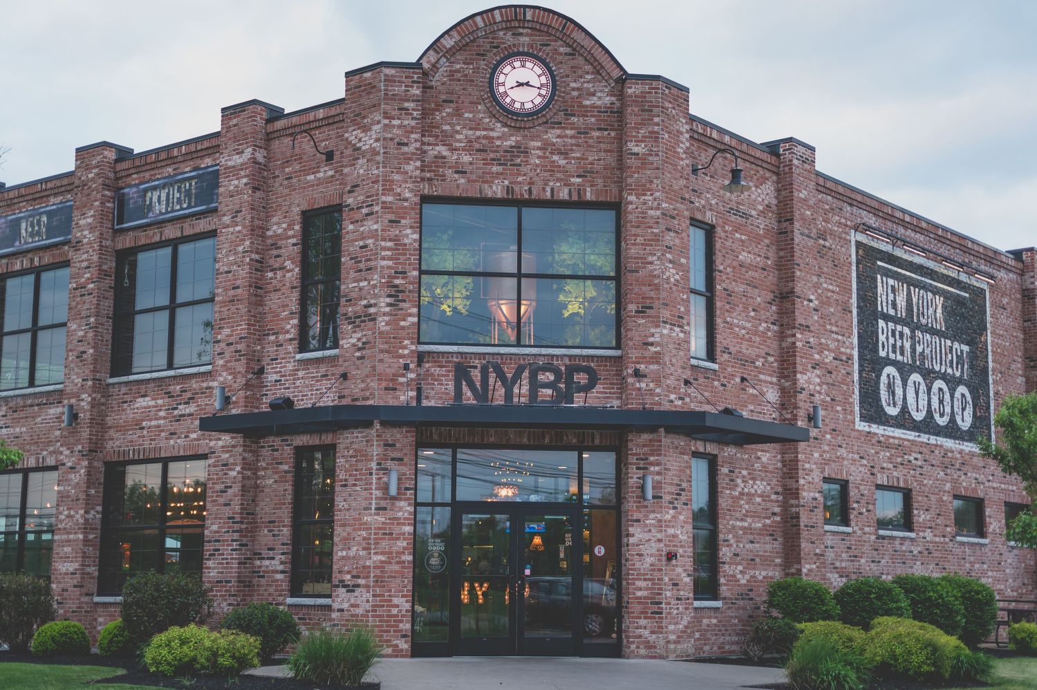 Exterior view of brick building with clock tower and NKP signage.