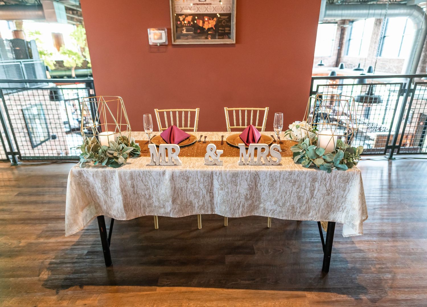 An elegant wedding reception table with lace tablecloth and floral centerpieces.