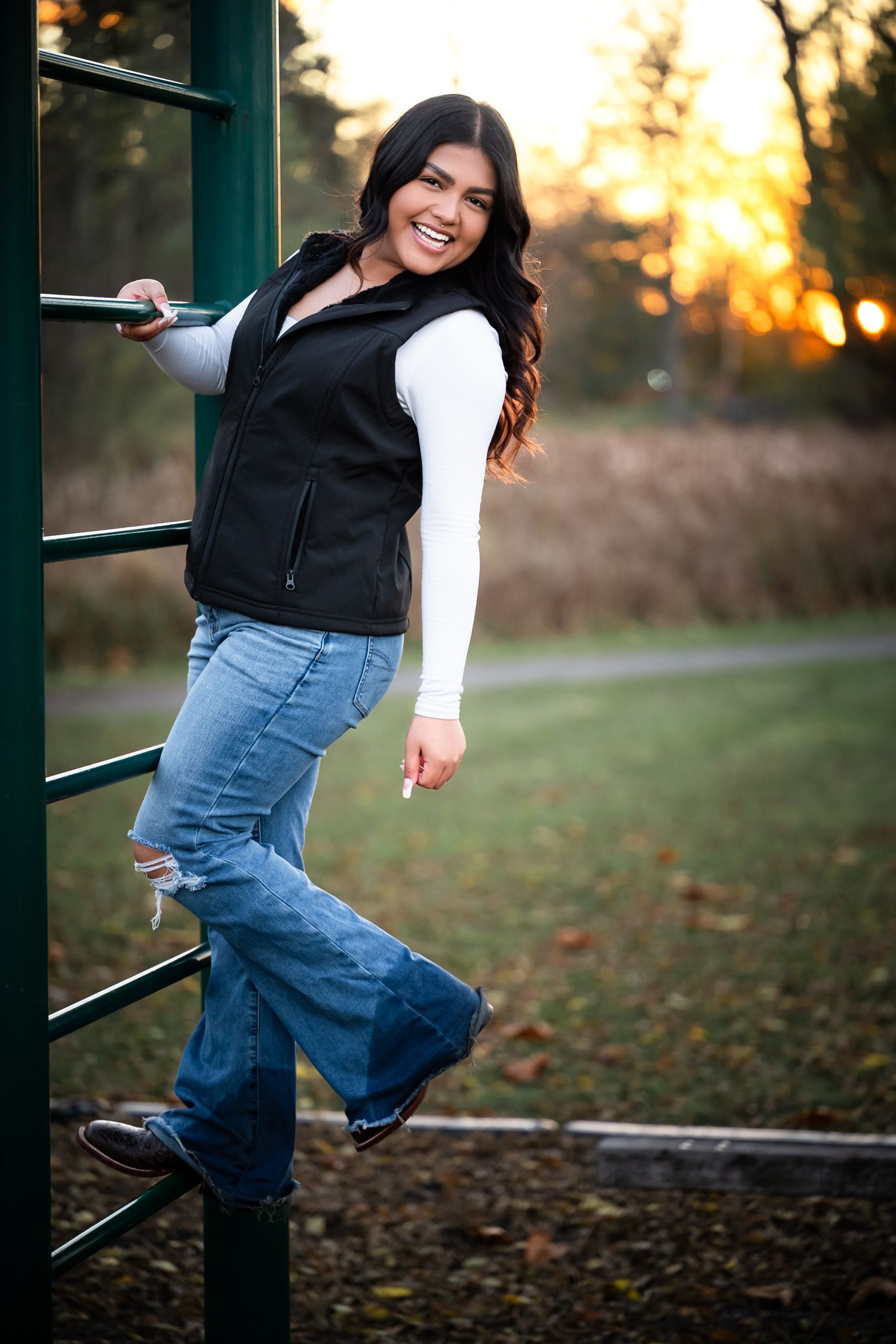 A series of outdoor portrait photos showing someone in jeans and black vest posing playfully against a sunset backdrop.