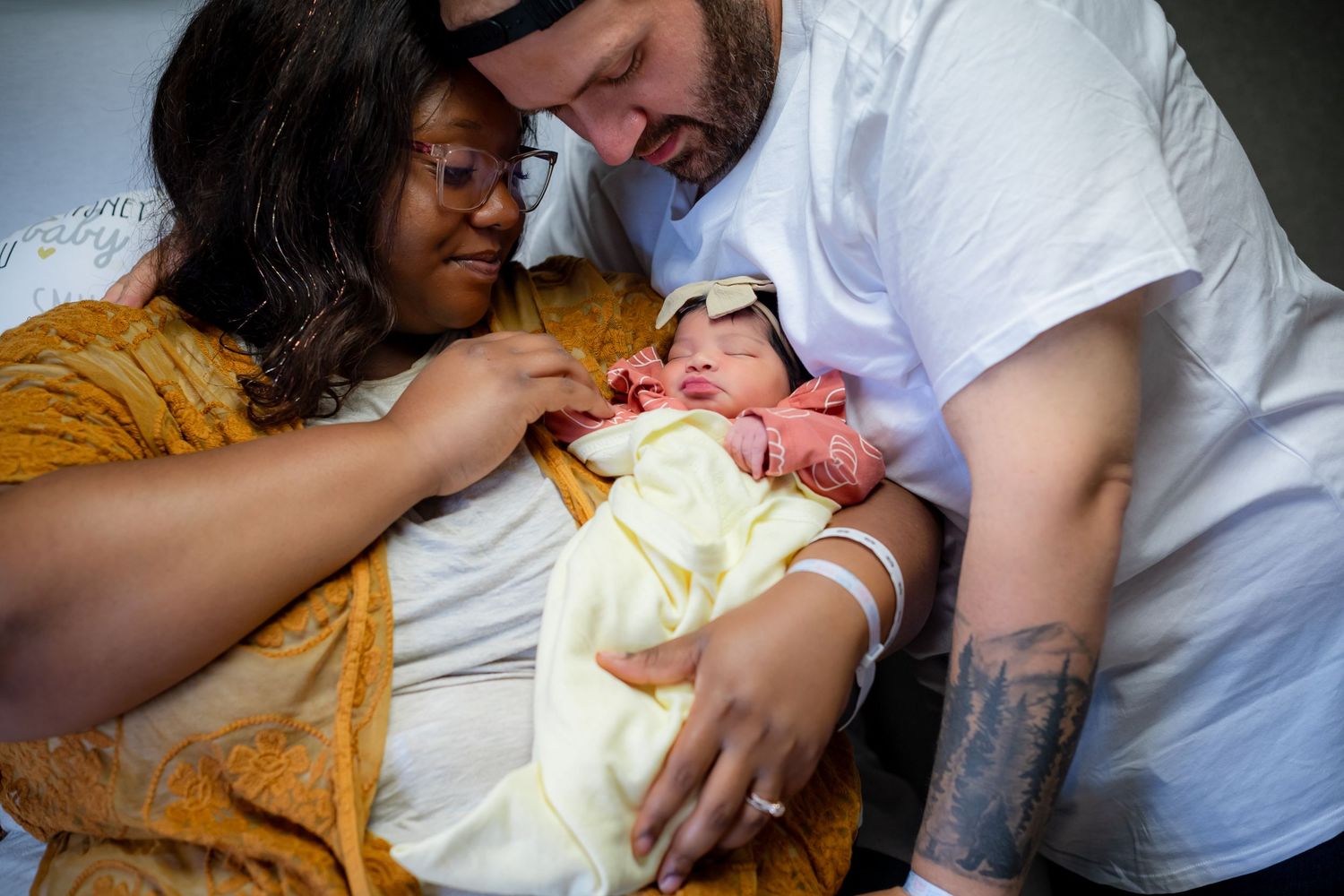 Parents tenderly caring for their newborn baby in hospital setting.