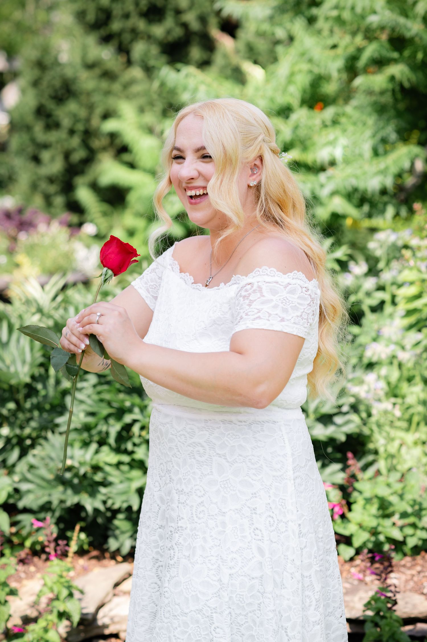 A joyful moment in a lush garden setting with a red rose.