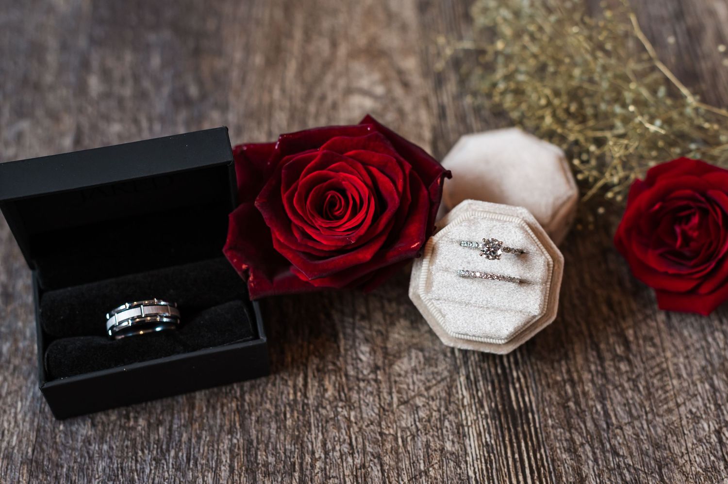 Deep red roses and delicate white paper notes arranged on rustic wooden surface create romantic ambiance.