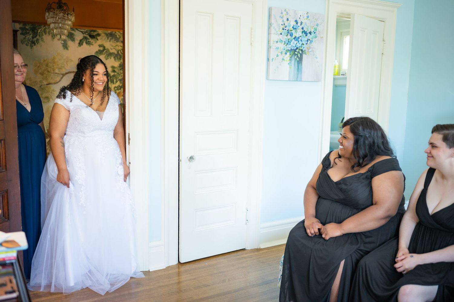 A wedding gown fitting session with attendees seated in a bright room.