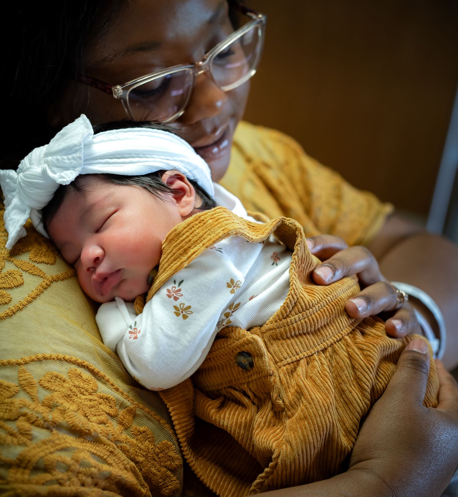 A series of tender moments showing a baby in a mustard yellow sweater resting peacefully.