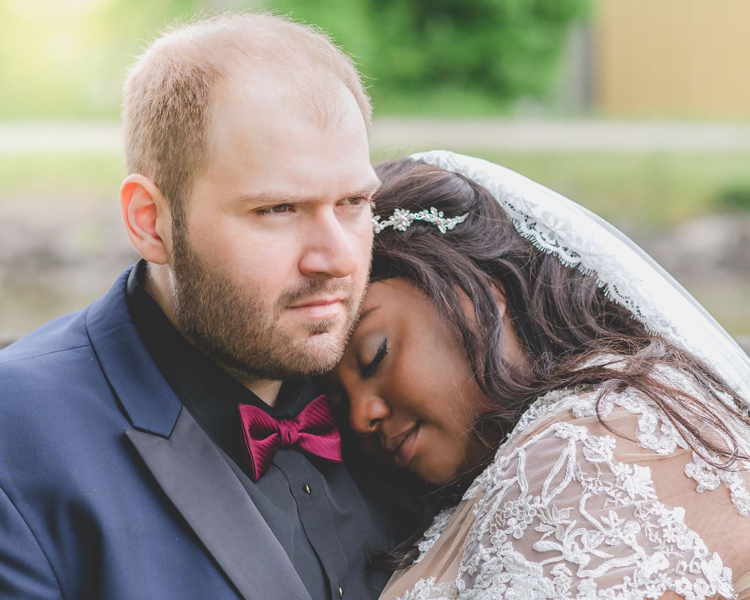 An intimate wedding portrait shows tender moment between newlyweds.
