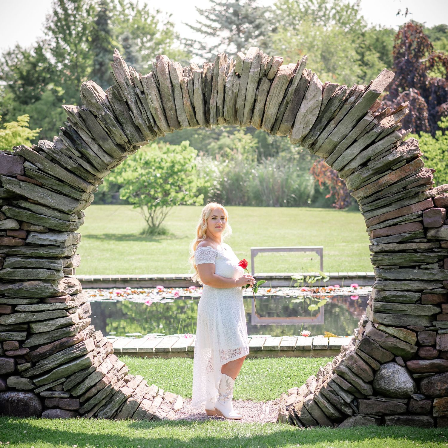 Circular stone archway frames a peaceful garden scene with summer greenery.