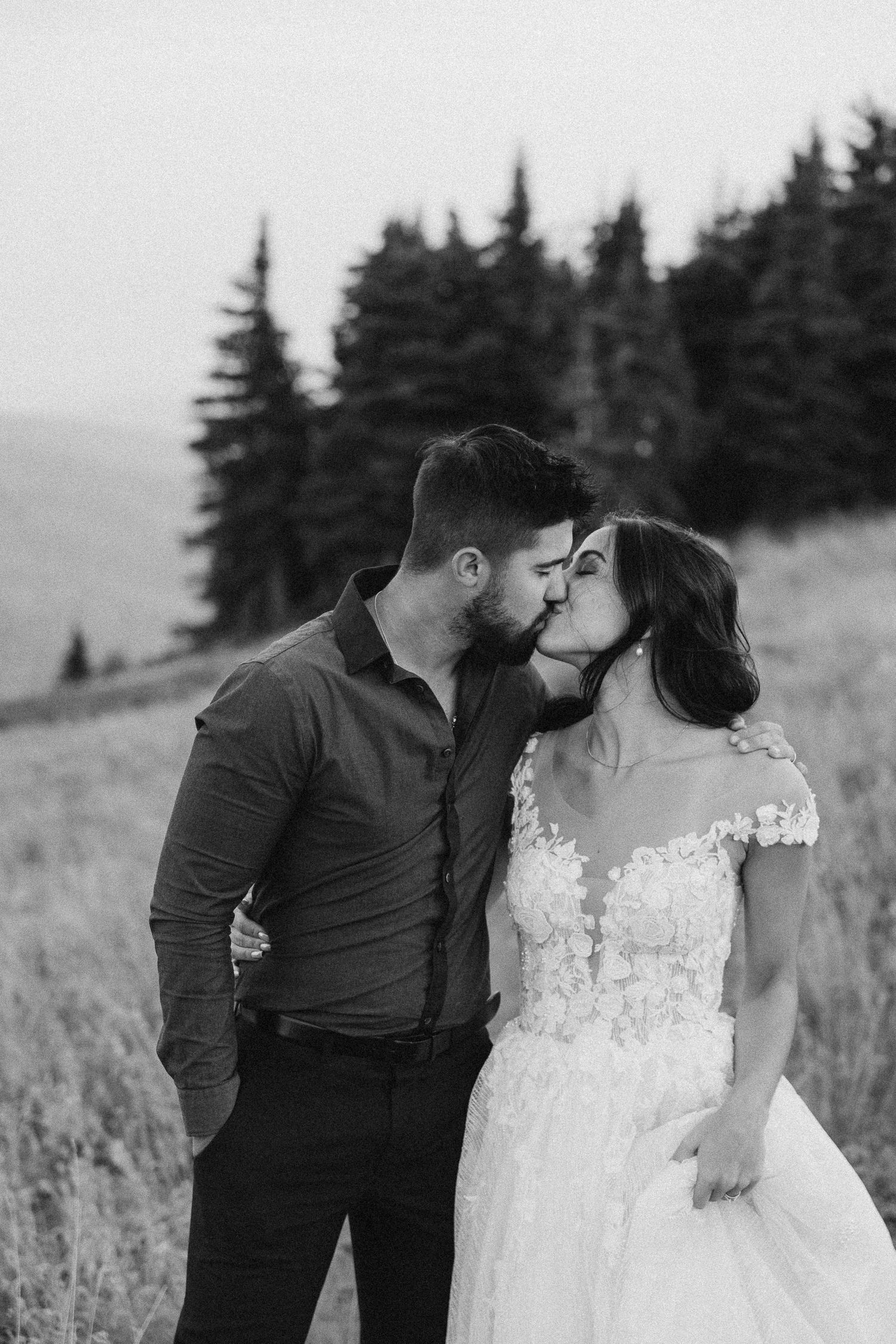 bride and groom kissing on a mountain top
