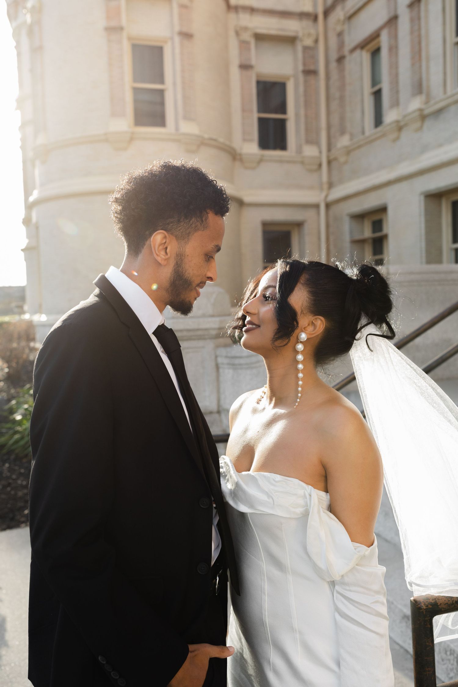 bride and groom looking at each other during golden hour at the spokane city hall
