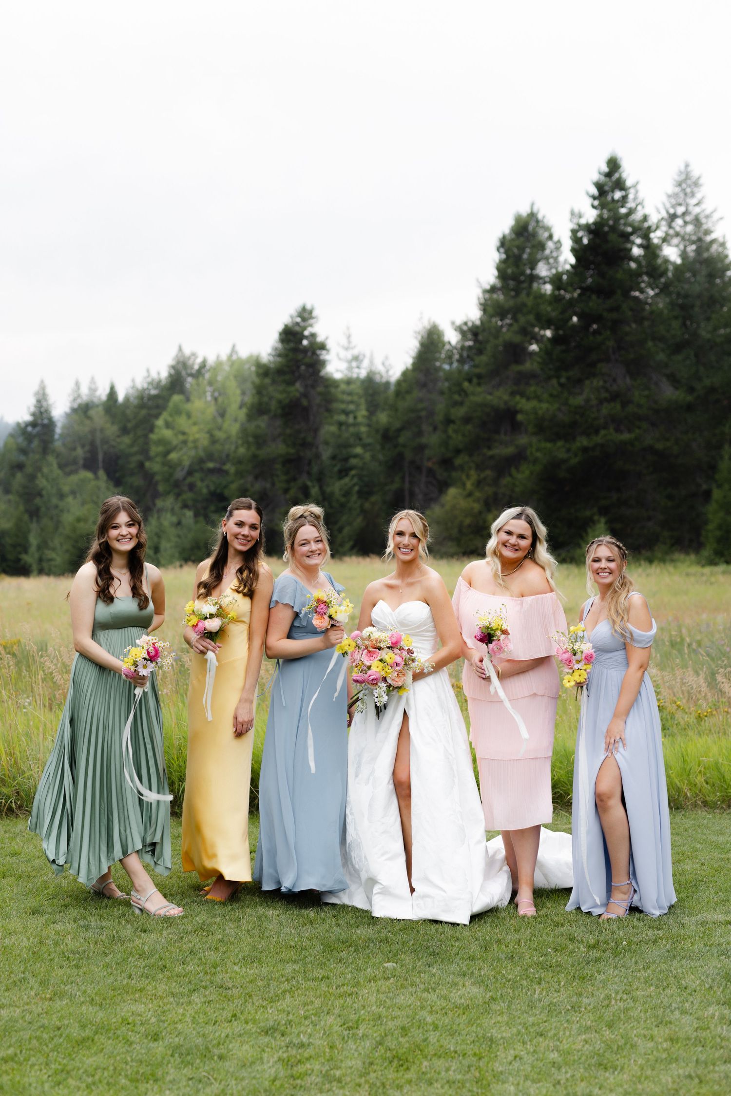 bridesmaids wearing colorful dresses posing in a Washington wedding venue