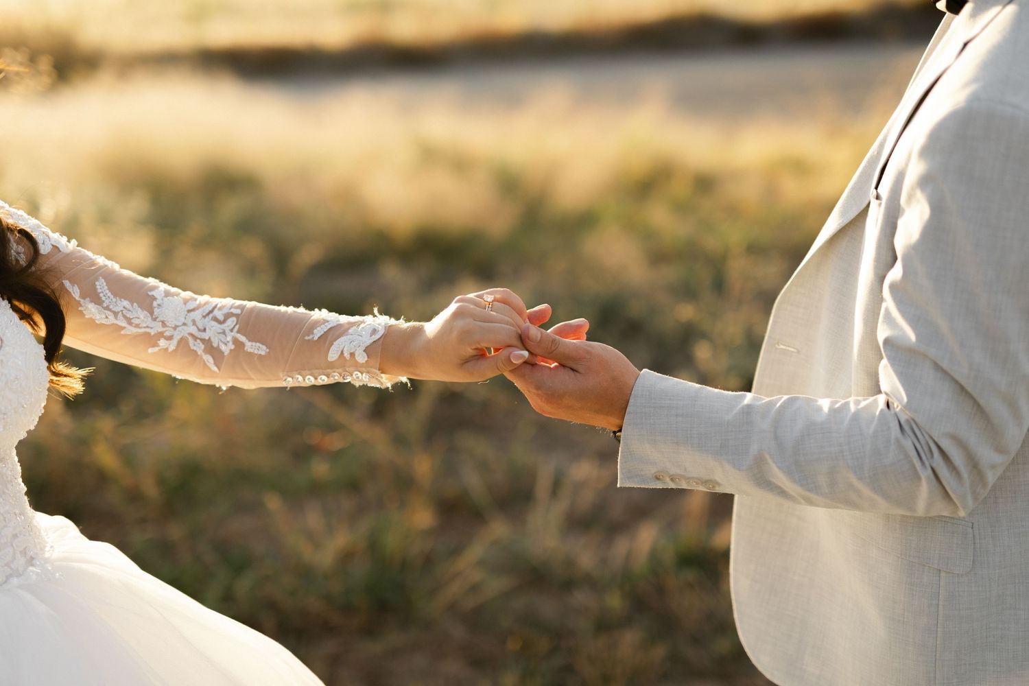 detail photo of a couple reaching for each other's hands during golden hour