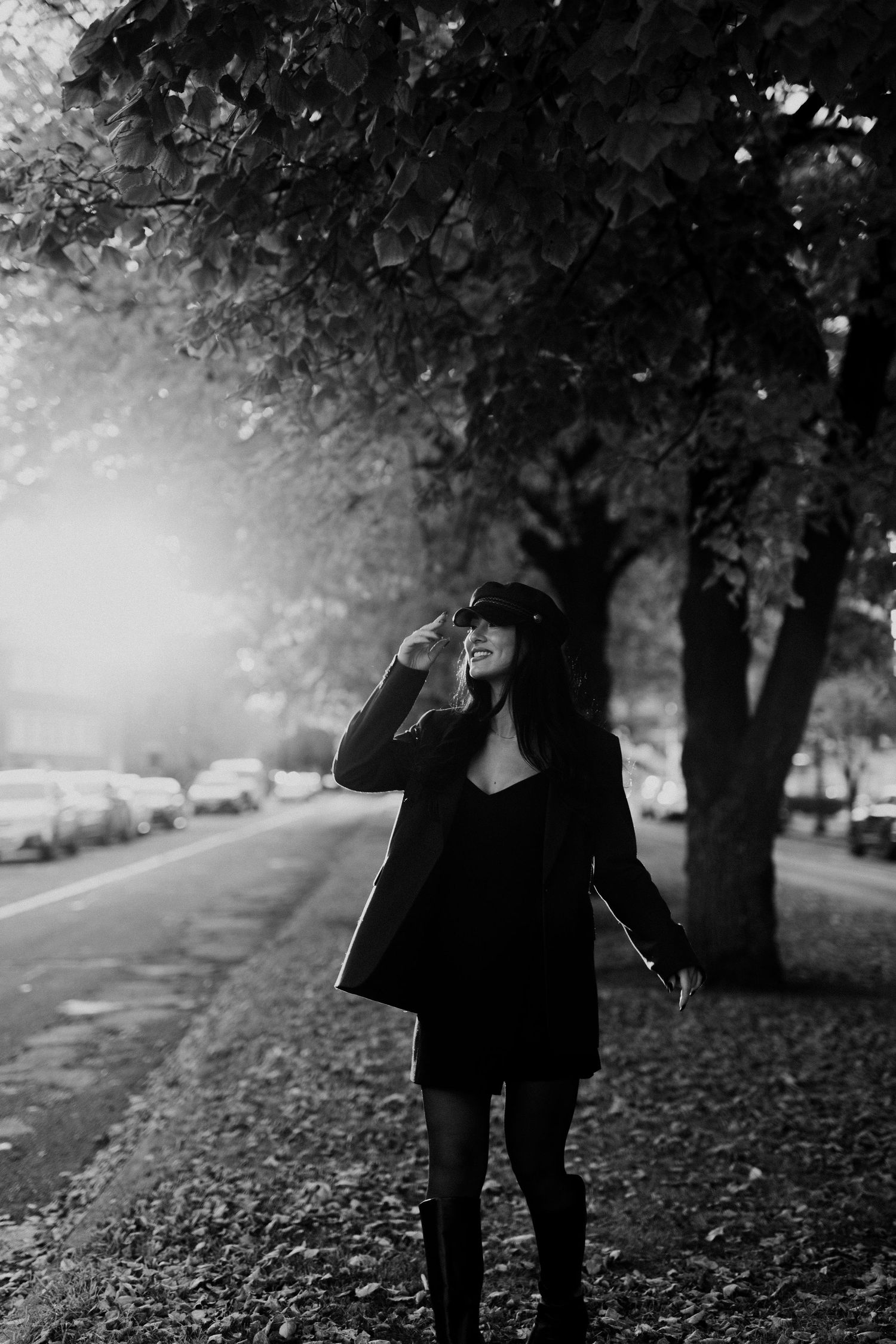 Woman holding a hat strolling through downtown on a fall day