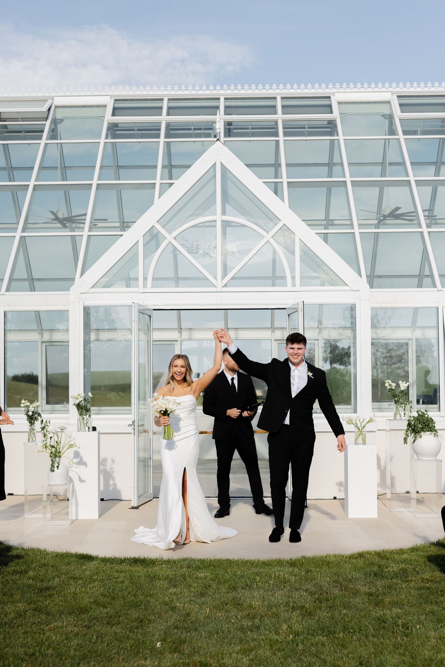 Bride and groom cheering holding up hands as they are pronounced husband and wife