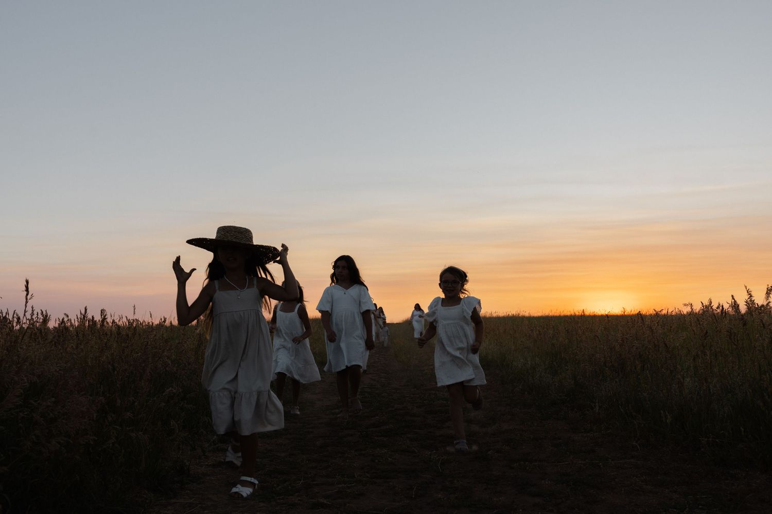 kids running in a field during sunset