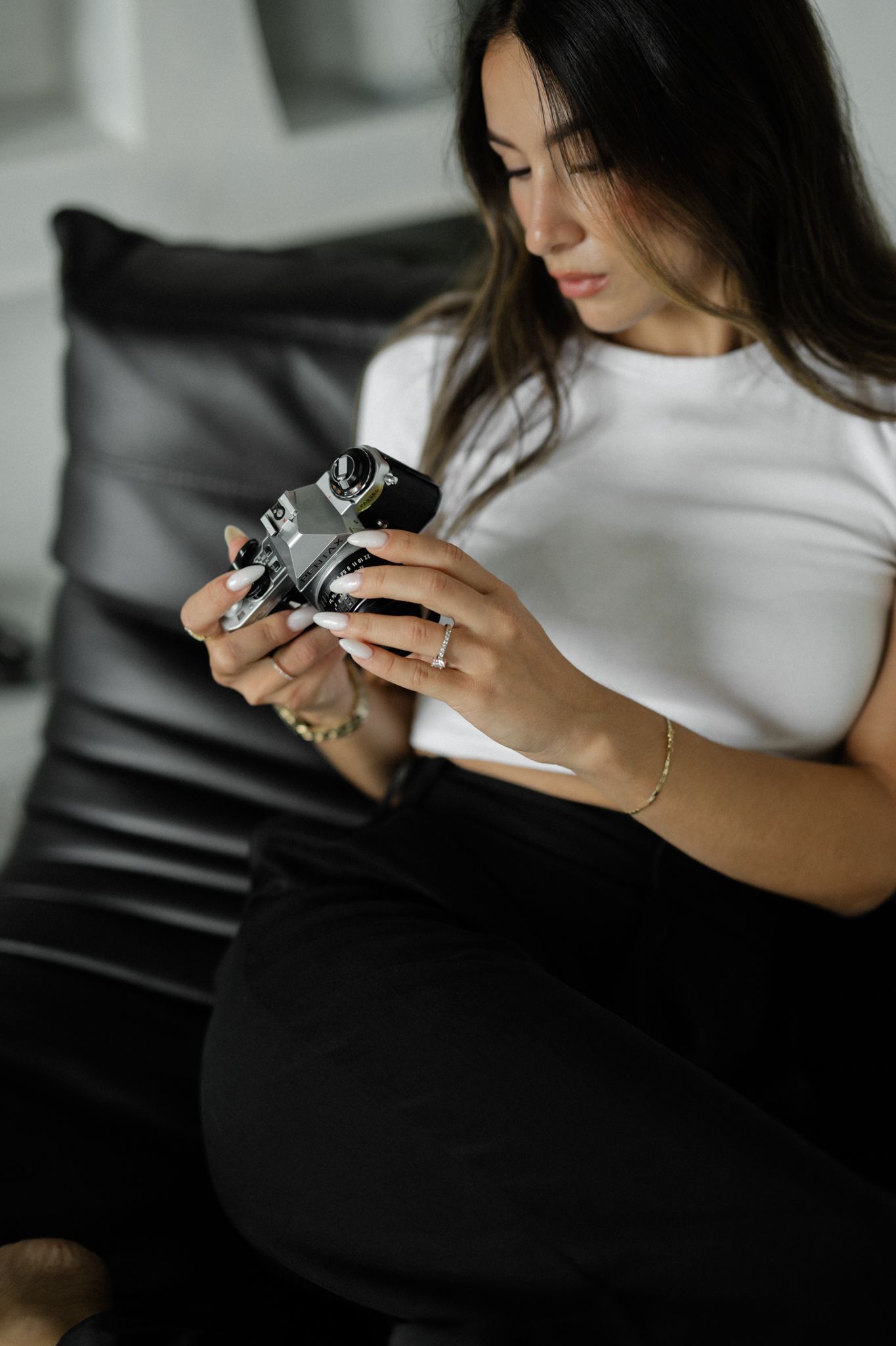 woman sitting, taking a photo on her film camera
