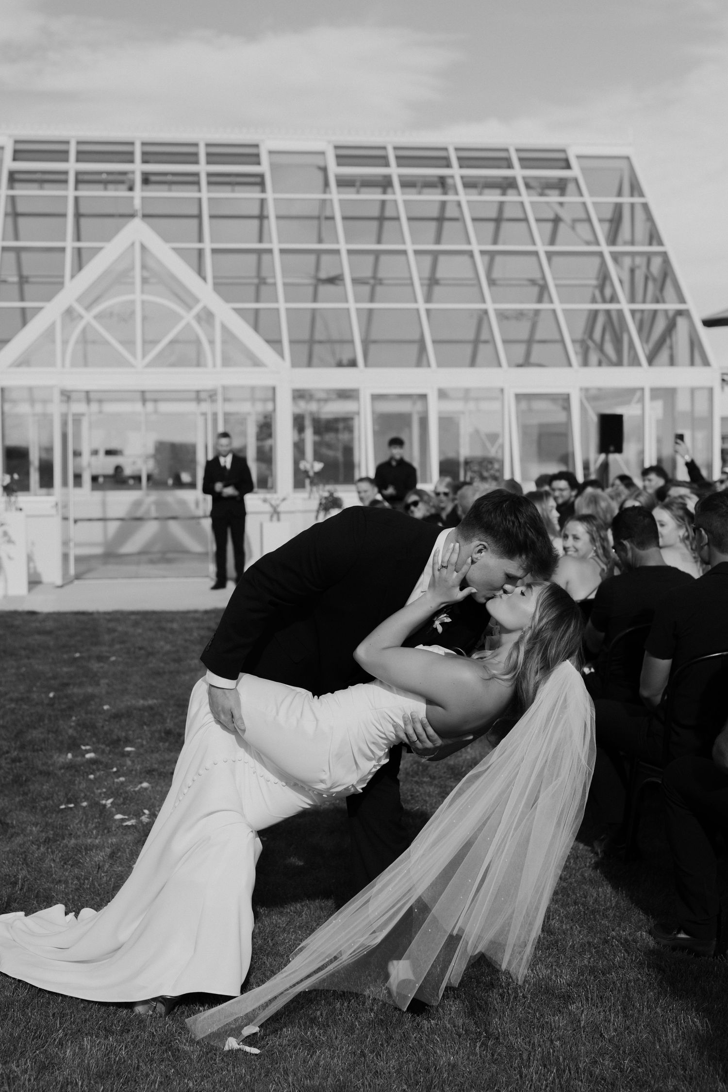 Bride and groom dip and kiss as they walk away from their ceremony