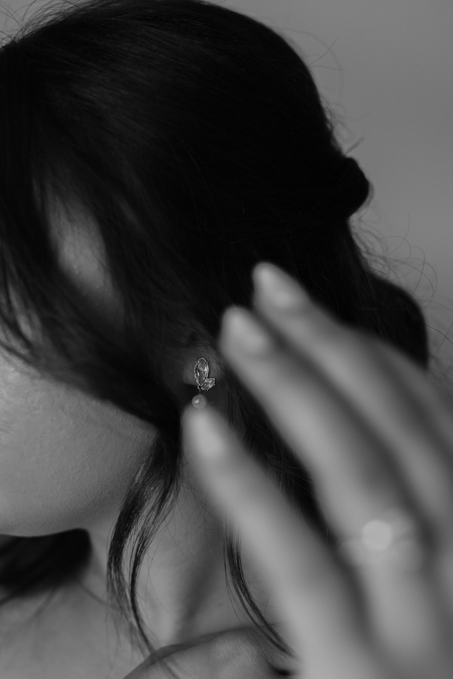 detail of bride putting on her earing
