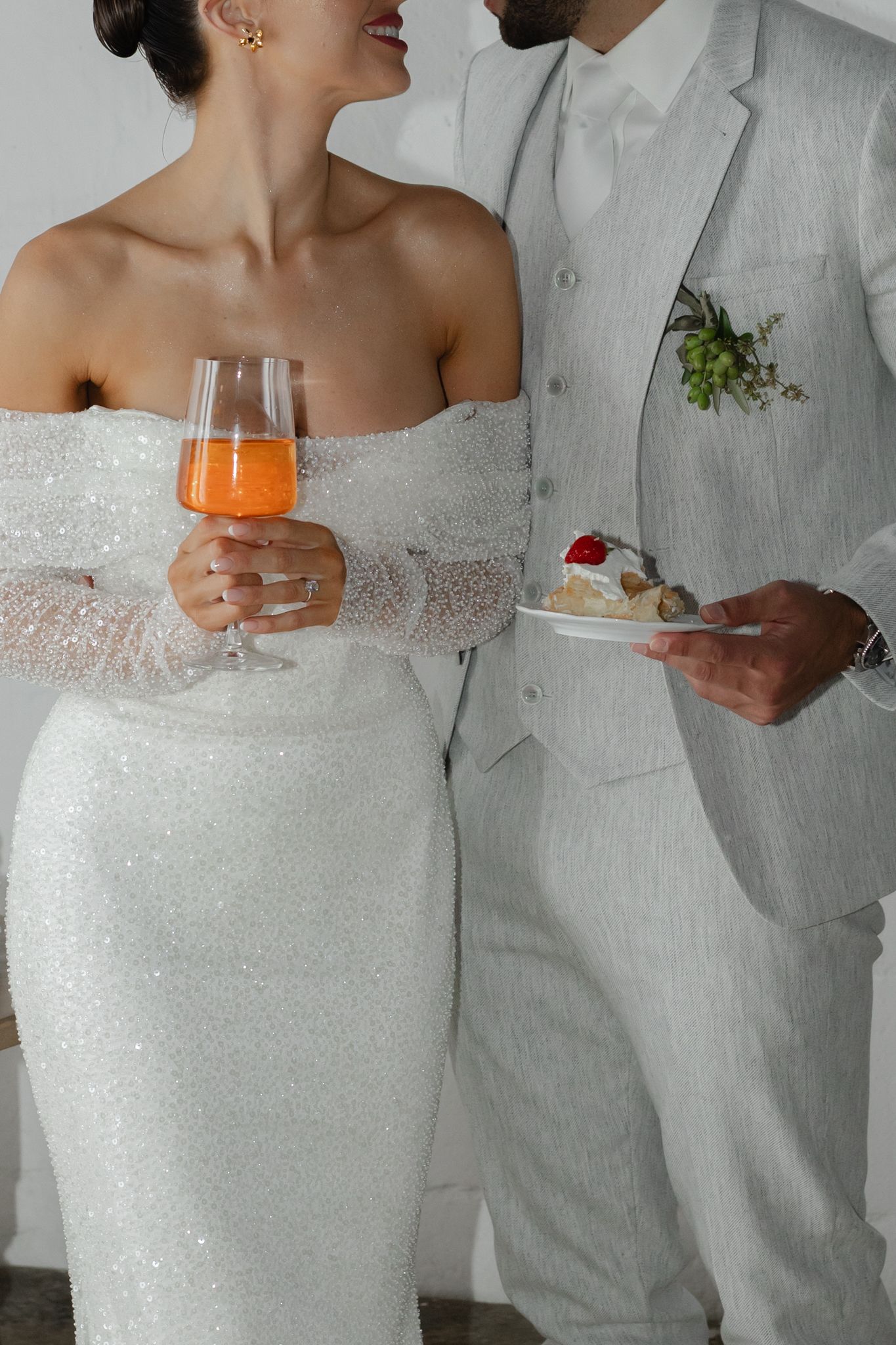 Bride and groom flash reception photo of them eating cake and drinking Aperol spritzes in ostuni puglia