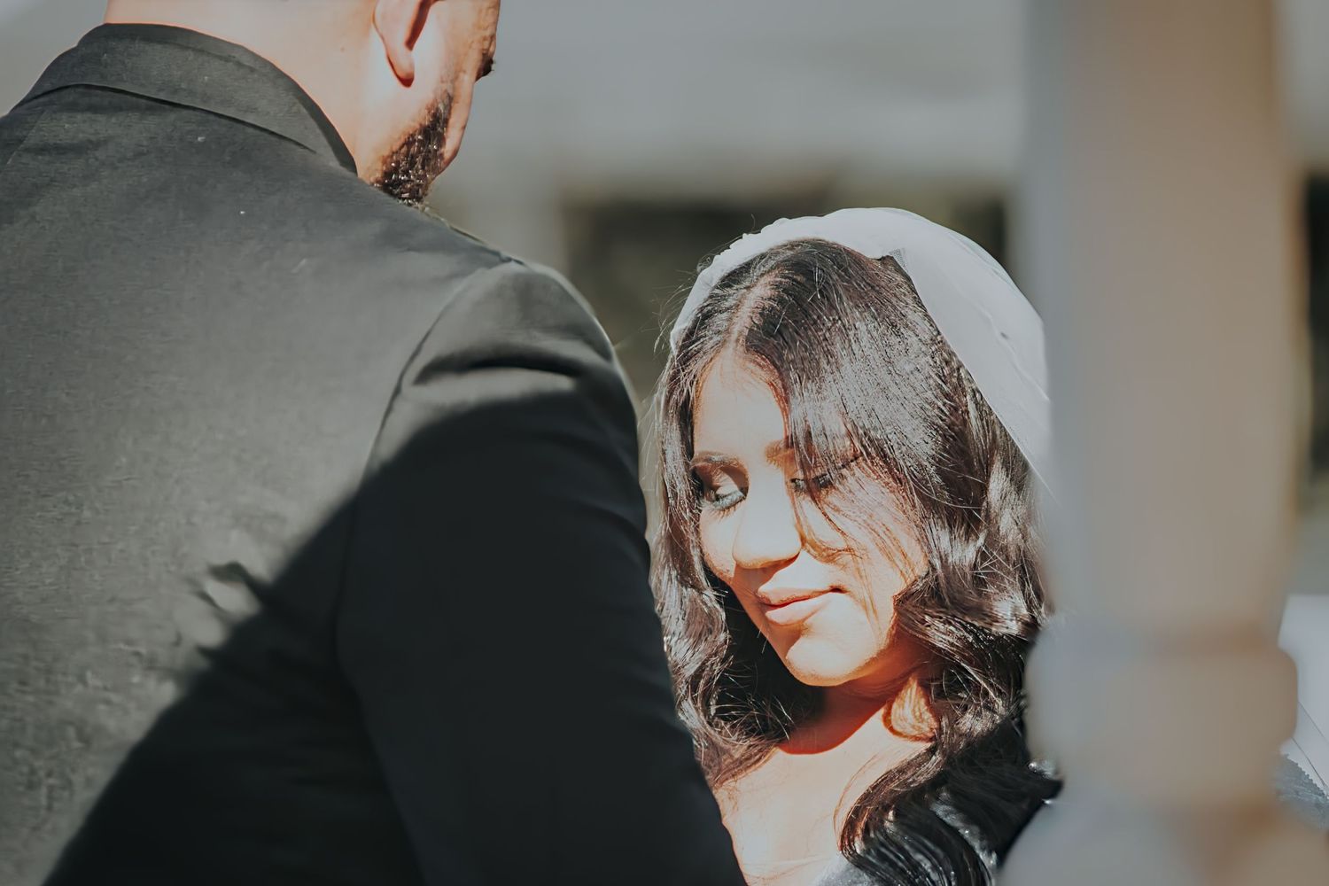 Close up of bride and groom sharing an intimate moment during wedding photoshoot in soft natural light.