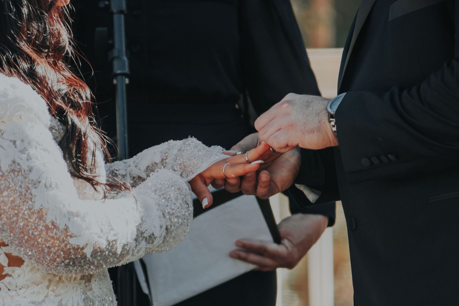 Close-up shot of exchanging rings during a traditional wedding ceremony.