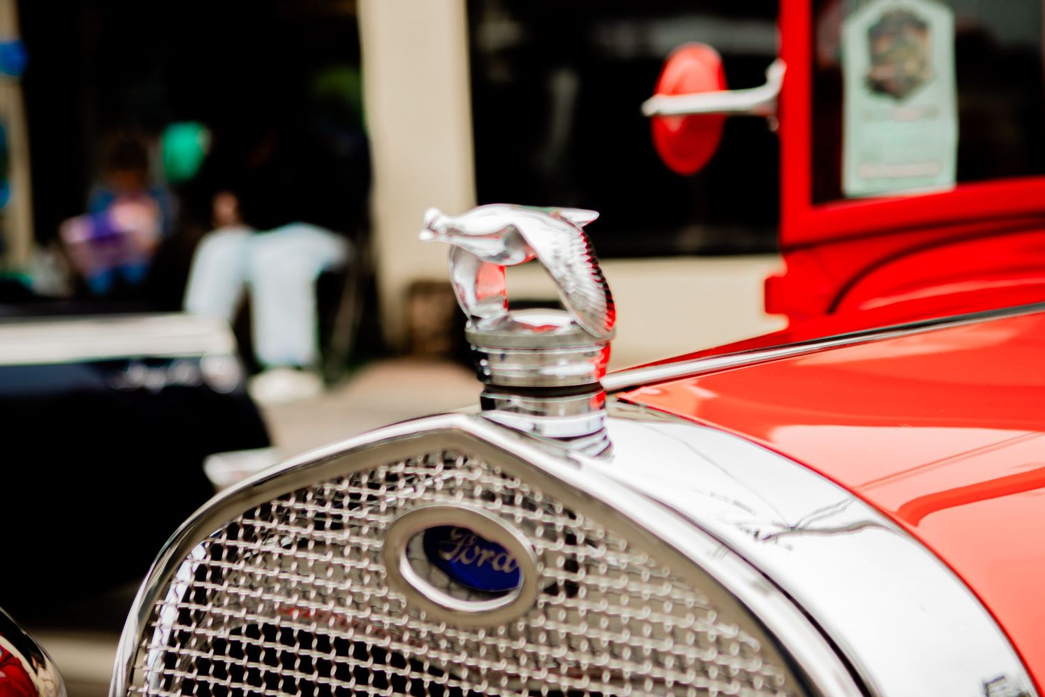 Chrome hood ornament on a vintage Ford automobile featuring a classic leaping greyhound design in chrome.